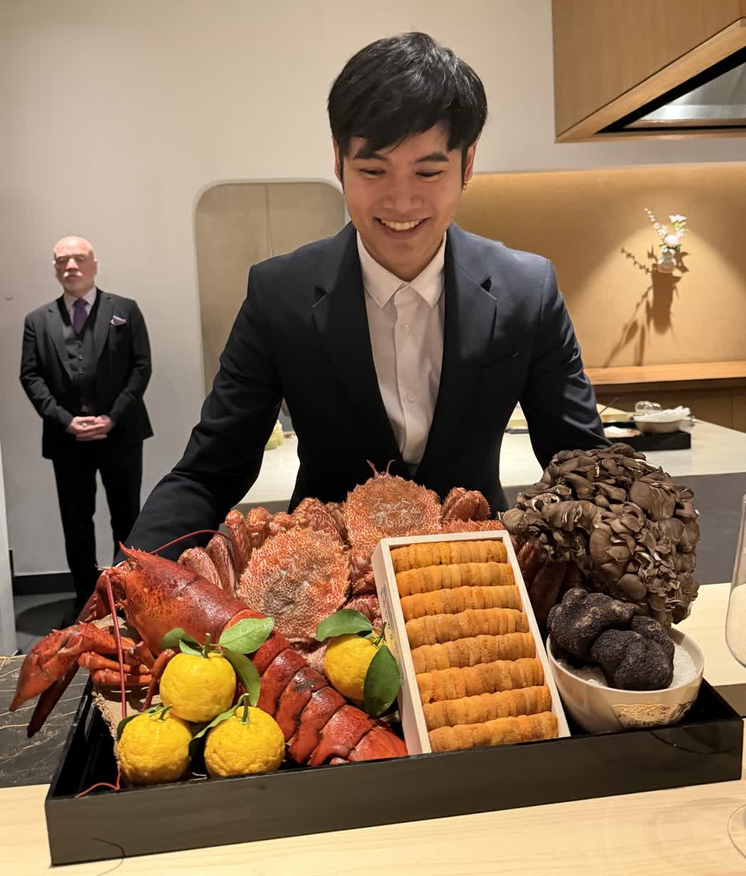 A tray of raw ingredients presented to us: whole lobster, red king crab, a wooden box of sea urchin, a heap of maitake mushrooms, black truffles and yuzu