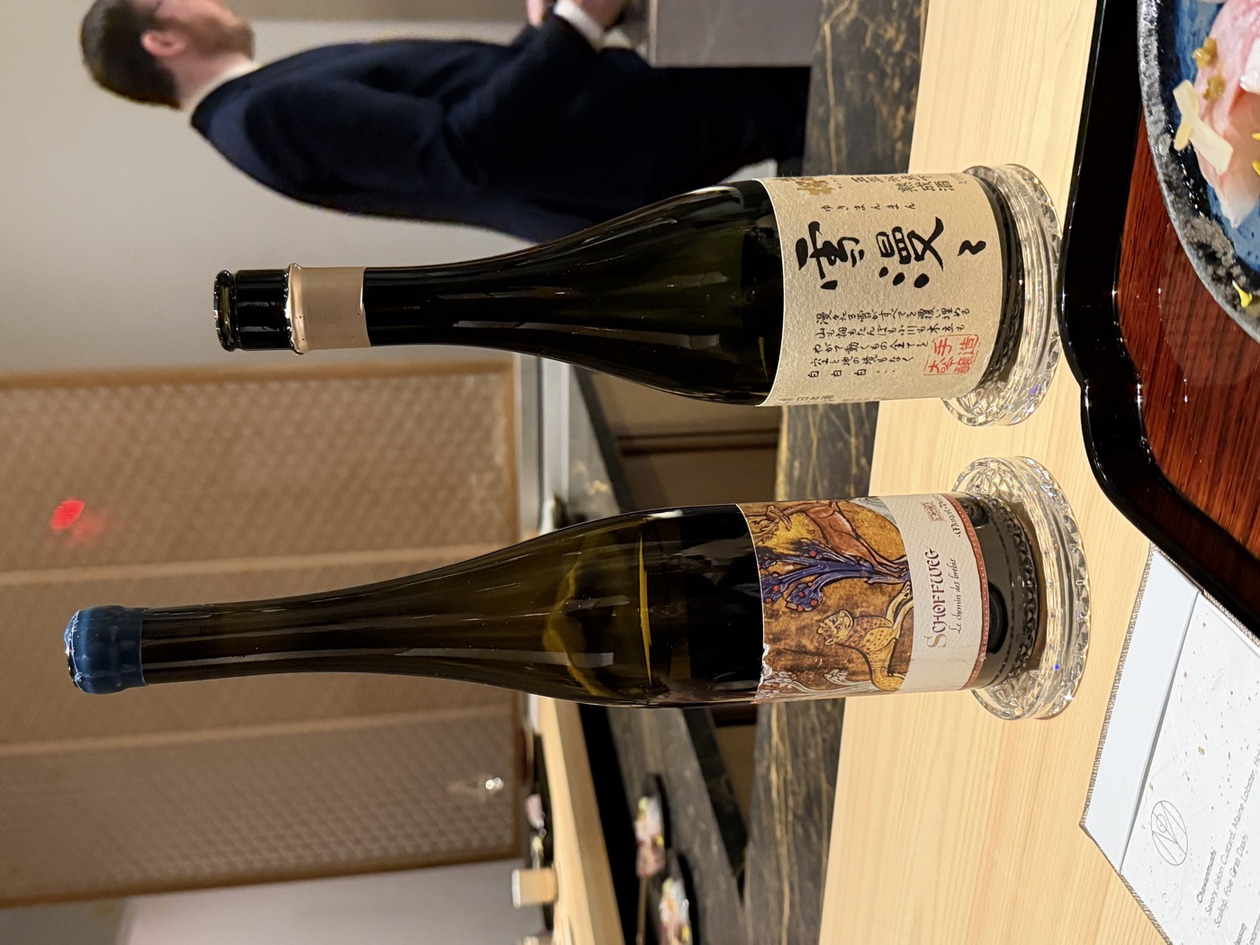 Two bottles — an aged Japanese sake labelled Yukimanman and a German Riesling