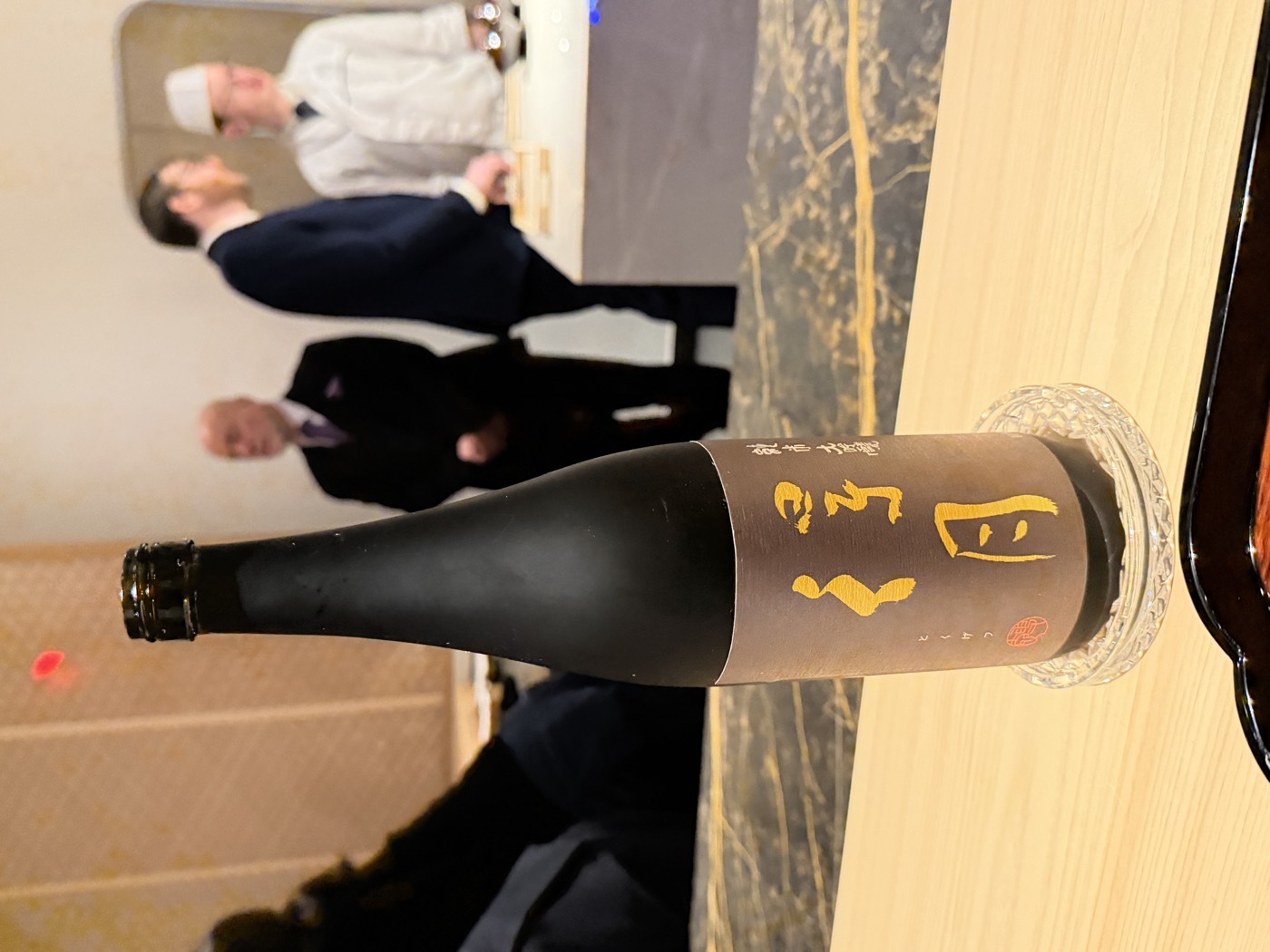 A black bottle of Tokugetsu junmai daiginjo sake with gold lettering