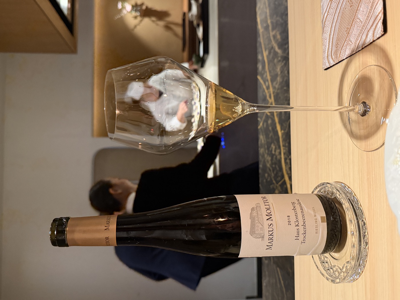 A bottle of Markus Molitor Riesling Trockenbeerenauslese with a glass of golden wine