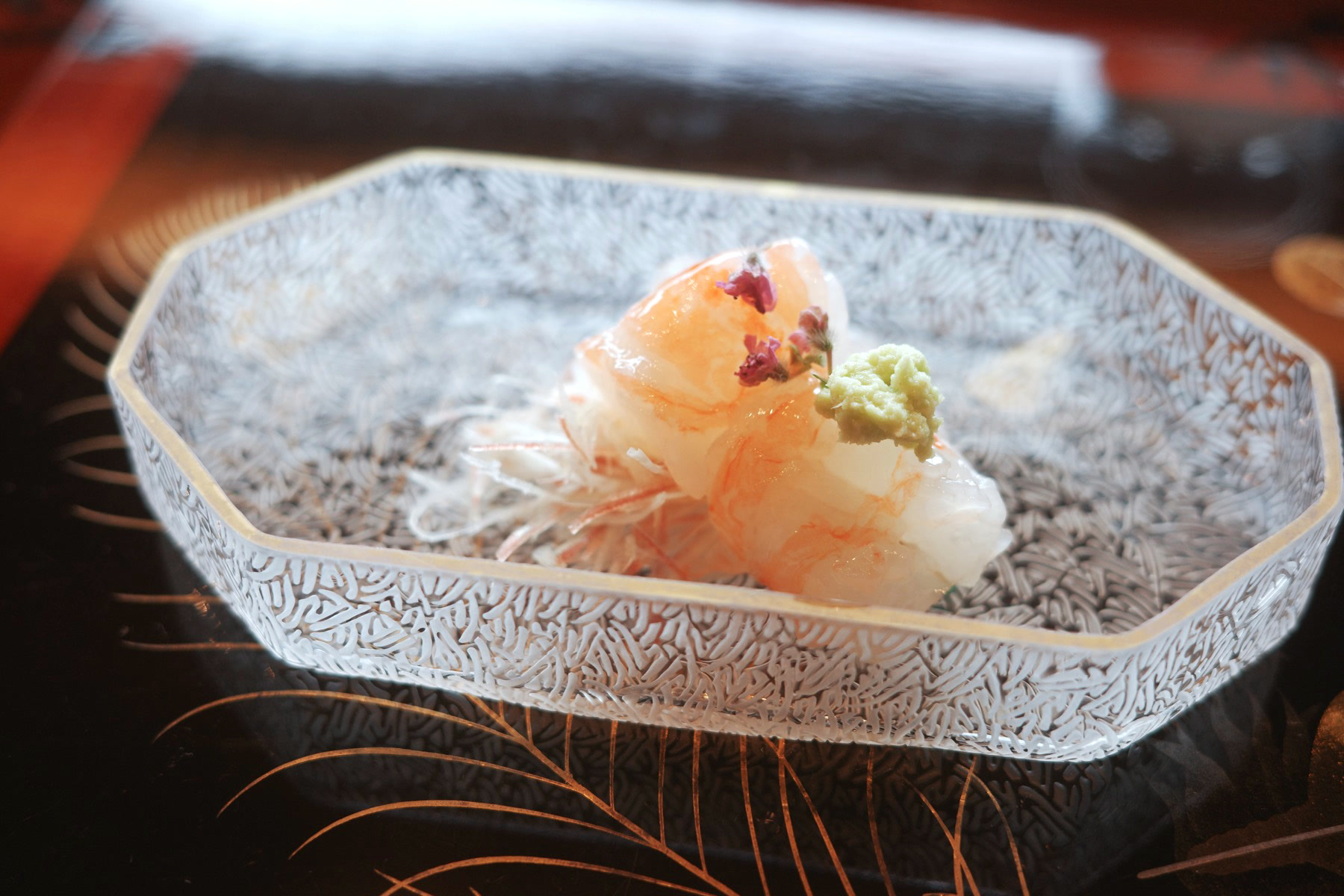 The peeled shrimp served as sashimi on a textured glass dish