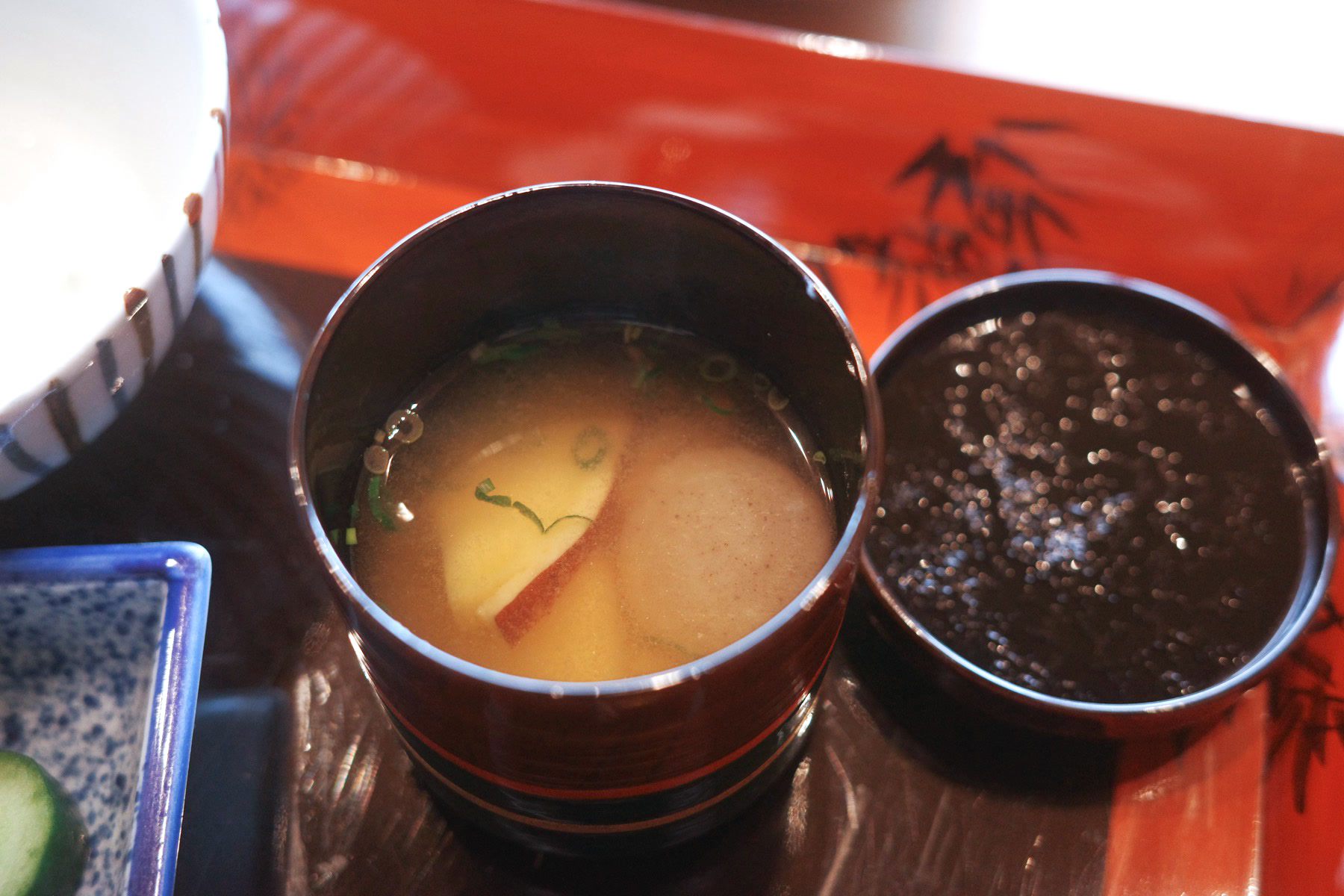A lacquer cup of red miso soup beside the rice