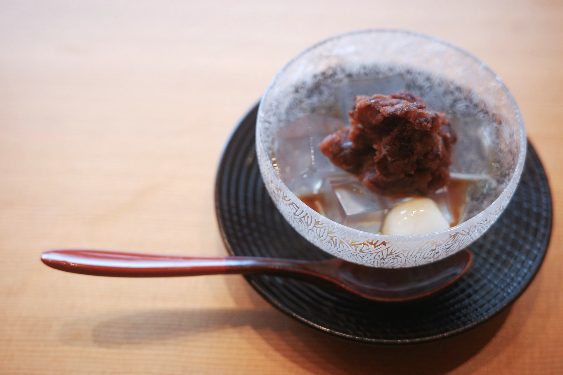 Anmitsu — cubes of clear agar jelly topped with red bean paste and a glutinous rice dumpling, in a frosted glass bowl