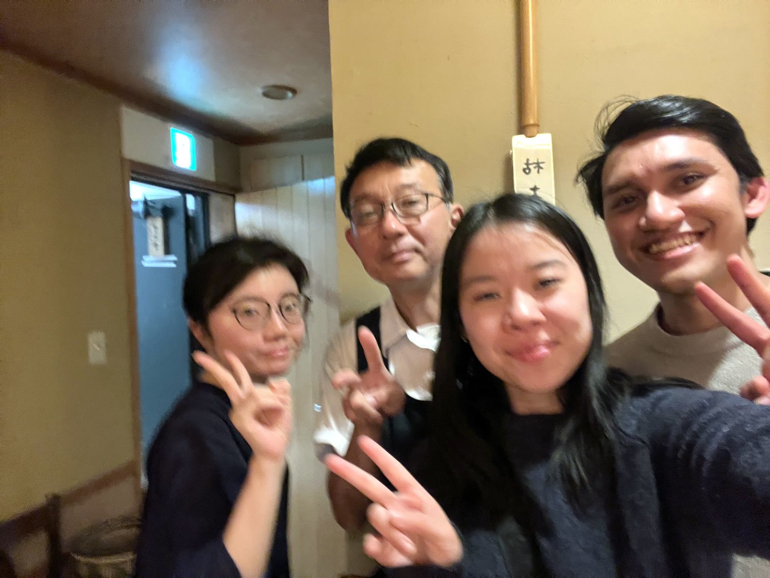 The four of us throwing peace signs at the end of the dinner